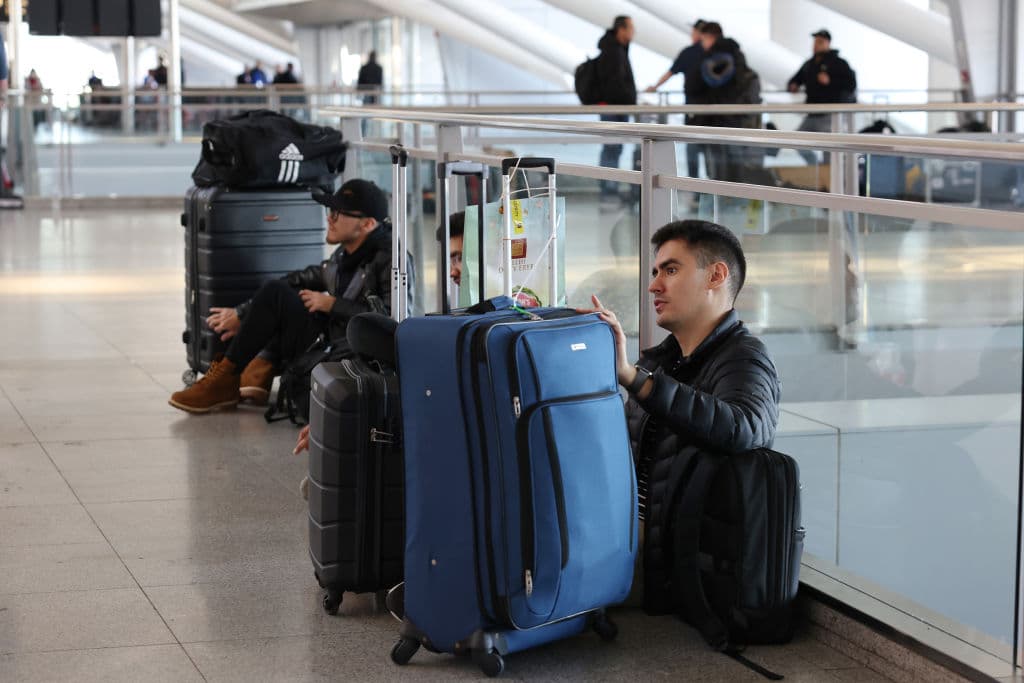 En JFK, viajeros esperan con maletas y regalos con la intención de reunirse con sus seres queridos. Este año se espera un aumento del 2 % en comparación con 2023.