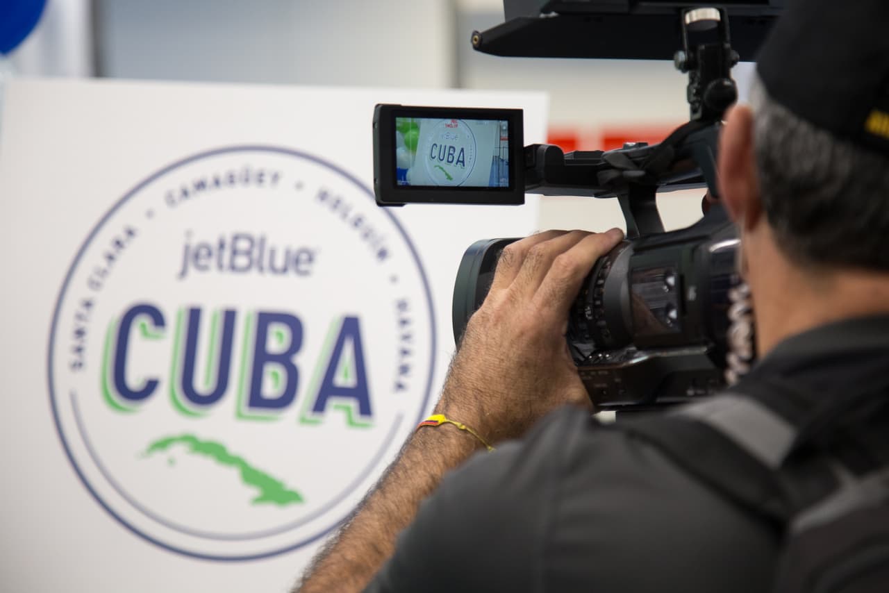Un camarógrafo graba el panel de bienvenida a invitados especiales en la zona de embarque del aeropuerto de Fort Lauderdale. El histórico vuelo 387 de JetBlue generó una inusitada cobertura mediática, al punto que el gerente de la compañía manifestó que "nunca vio semejante interés mediático en un vuelo".
<br>