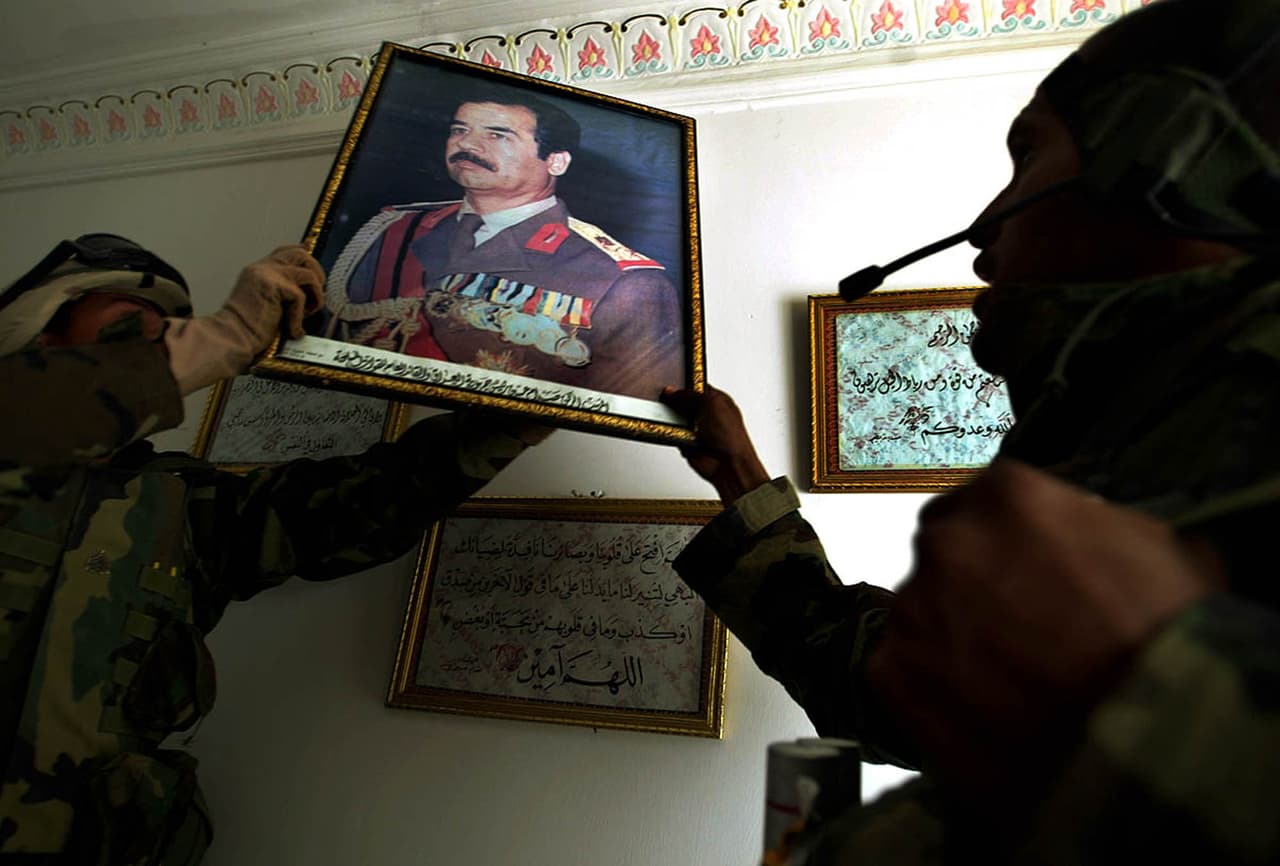 Militares estadounidenses retiran un retrato de Saddam Hussein de una base naval iraquí en Az Zubayar, tomada por el ejército de EEUU el 23 de marzo de 2003.