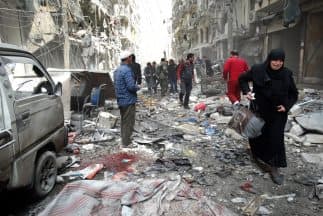 Una mujer de Siria llora al abandonar una cuadra residencial que fue atacada con un barril lleno de  explosivos que descargaron de un  helicóptero del gobierno.