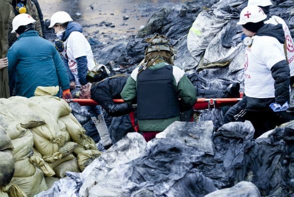 La policía ucraniana cercó hoy a los manifestantes en el corazón de las protestas opositoras de la plaza de la Independencia de Kiev (Maidán), tras una jornada en la que murieron 14 personas en los disturbios que estallaron en la capital. Víktor "Yanukóvich se ha convertido en un presidente sangriento", aseguró hoy el dirigente opositor Vitali Klitschkó en un llamamiento a los países democráticos para que intervengan en Ucrania y frenen la violenta confrontación. Según se acercaba la medianoche, los temidos Berkut, el destacamento antidisturbios, estrechaban el cerco en torno a los miles de manifestantes concentrados en el Euromaidán, bastión de las protestas desde el pasado 21 de noviembre. "Los extremistas de la oposición han cruzado la línea roja; matan a inocentes en la calles de la capital de Ucrania, vejan a mujeres, queman edificios y automóviles. Y si los disturbios continúan, nos veremos obligados a actuar con firmeza", rezaba el ultimátum del Servicio de Seguridad y el Ministerio del Interior de Ucrania. Advierten a los americanos que se queden dentro de las casas y de nuevo se sienten explosiones en la ciudad.
