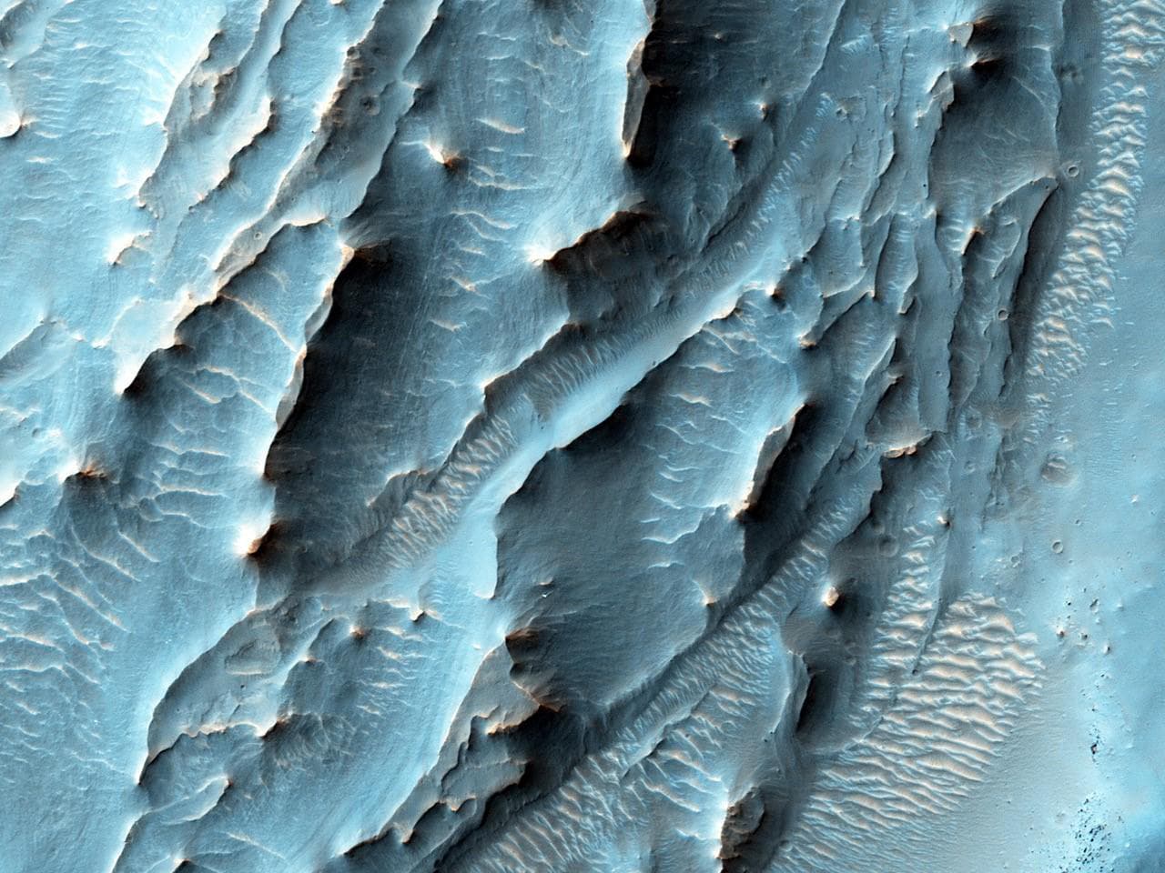 Esta vista de una zona con una textura inusual dentro de un cráter fue tomada por la cámara HiRISE del orbitador 
<a href="https://mars.nasa.gov/mars-exploration/missions/mars-reconnaissance-orbiter/"><u>Reconnaissance</u></a>. Un día en Marte tarda un poco más de 24 horas terrestres, pero su órbita completa alrededor del Sol (un año) toma 687 días.