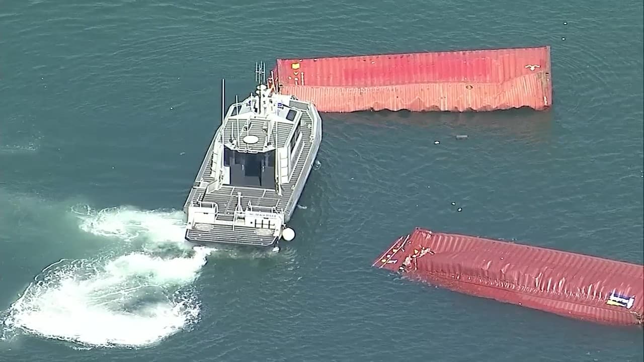 Se observó un barco más pequeño junto al buque de carga, aparentemente intentando recuperar los contenedores caídos, mientras un remolcador trataba de empujar otros contenedores hacia el muelle.