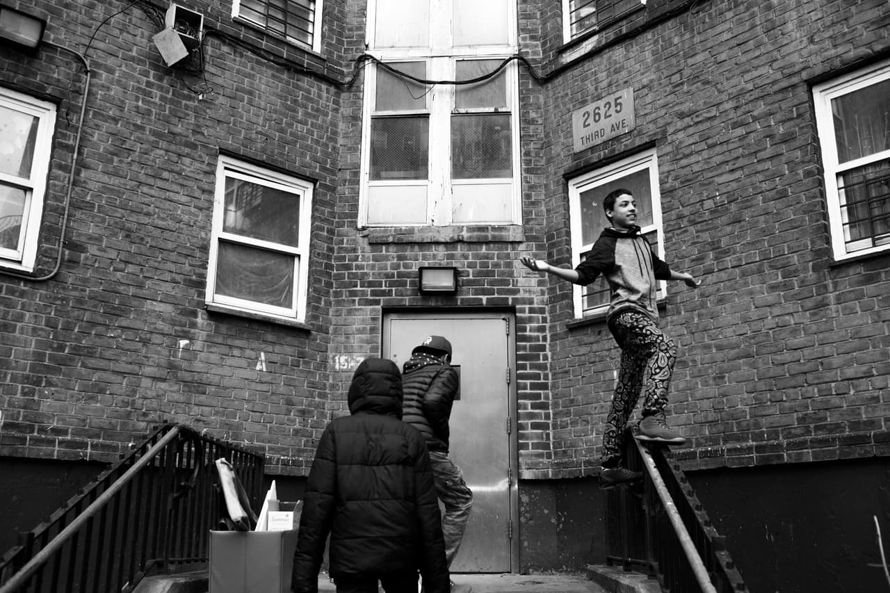 Edwin Amaro camina por la barandilla de la entrada de una construcción en el sur del Bronx. Está junto a sus amigos Cole Jeffers y Chavi León, el 27 Feb 2016,