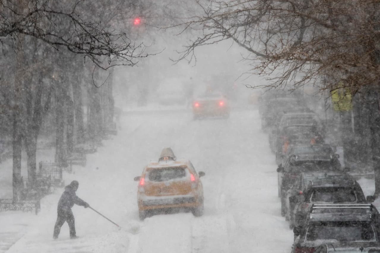 Los autos se desplazan sobre la nieve en el Upper Side de Manhattan, Nueva York.