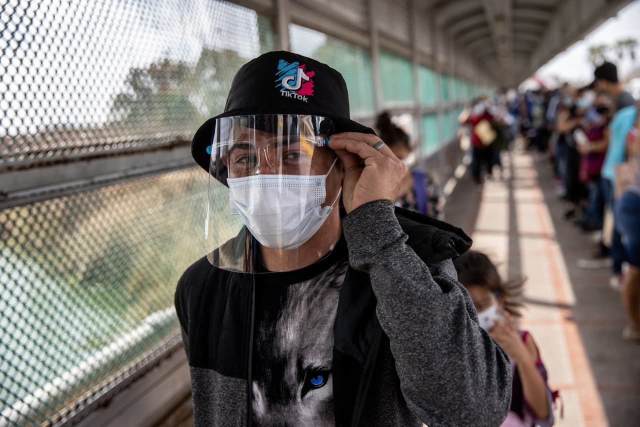 <b>Con careta y mascarilla. </b>Un solicitante de asilo cruza la frontera entre Estados Unidos y México. Él forma parte de un grupo fue el primero al que se le permitió cruzar al sur de Texas como parte de la revocación de los Protocolos de Protección al Migrante (MPP) de la administración Trump, también conocida como la política de inmigración 'Permanecer en México'.