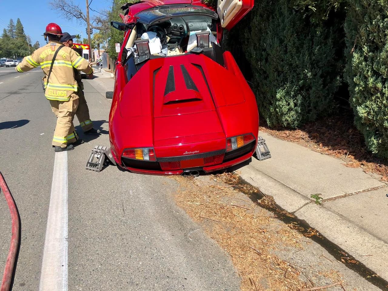 El vehículo tenía la parte de frente levantada unos 6 pies sobre el suelo luego de que el auto salió de la calle y chocó contra un alambre que sostiene un poste de electricidad anclado con la banqueta.