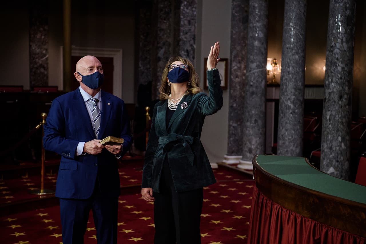 El exastronauta Mark Kelly con la biblia en mano mientras su esposa alza la mirada al cielo en señal de agradecimiento.