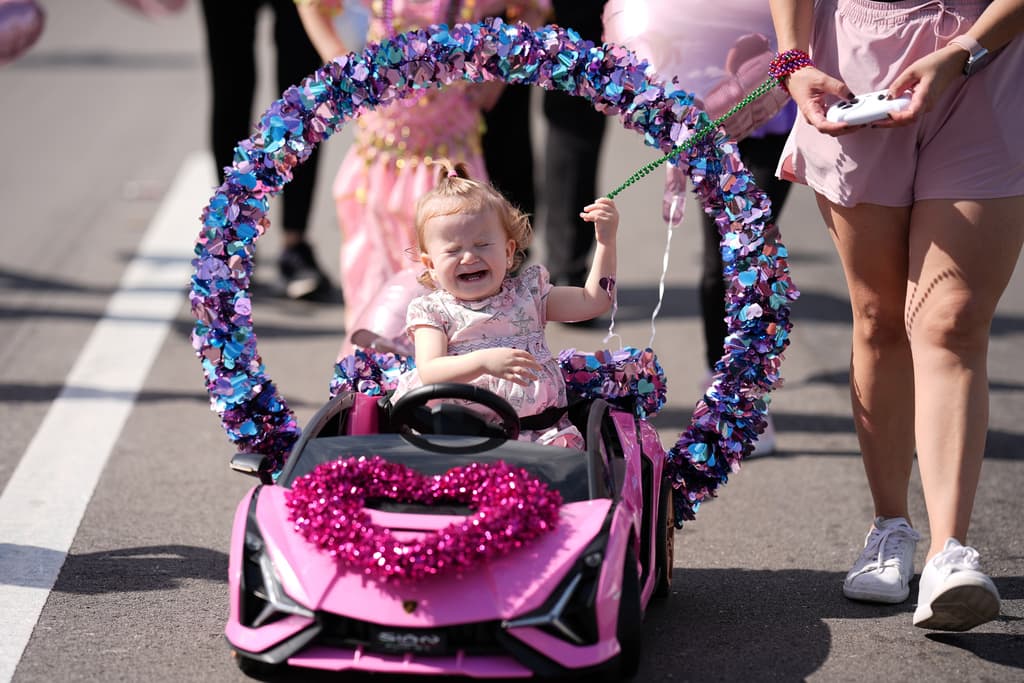 Una niña llora mientras va en su pequeño carrito en el Desfile de los Reyes Magos.