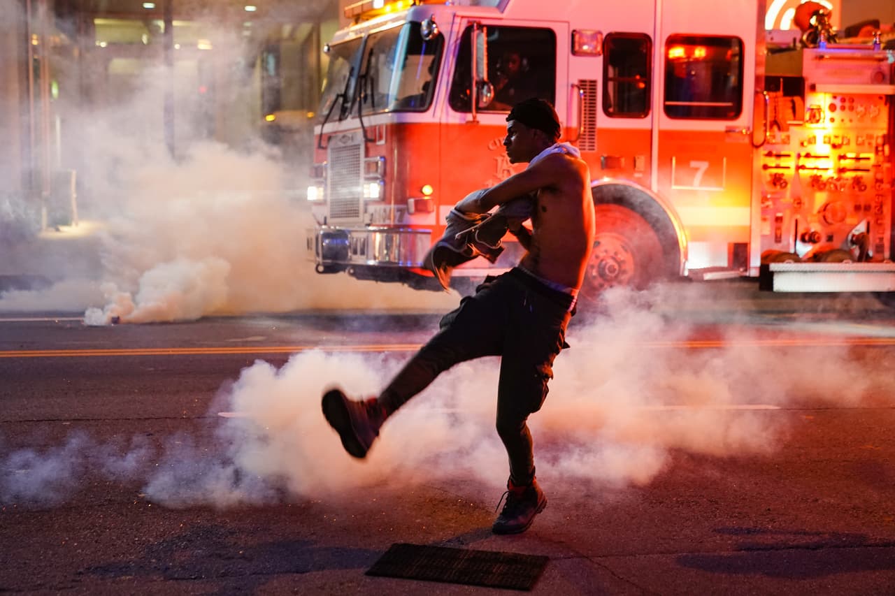 Un hombre arroja un bote de gas lacrimógeno durante una protesta el 29 de mayo de 2020 en Atlanta.