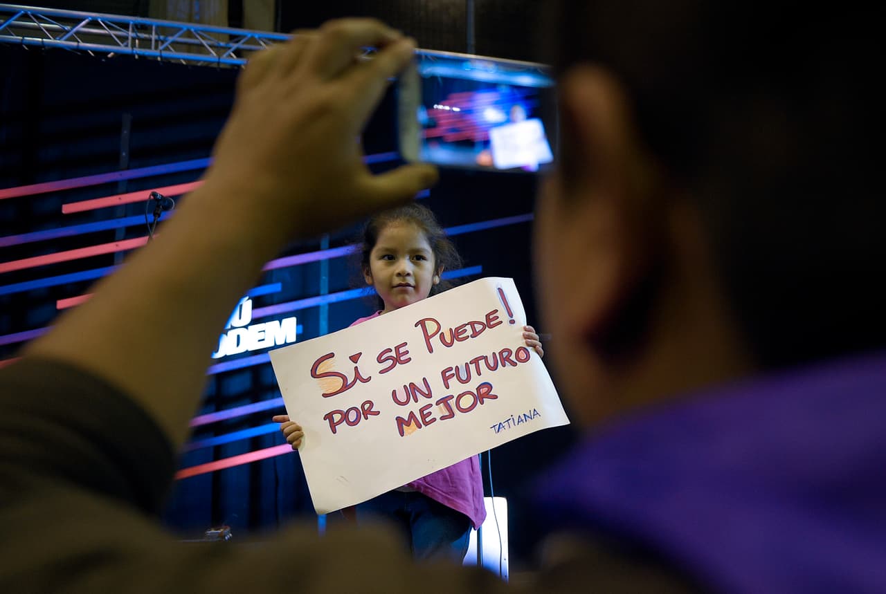 Una niña con un cartel en un acto electoral.