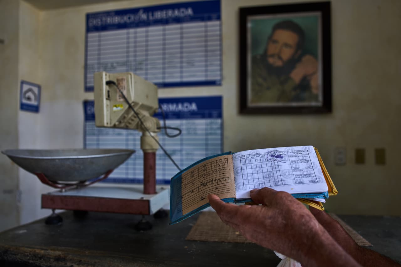 Un hombre muestra su cartilla de racionamiento, conocida como "libreta".
