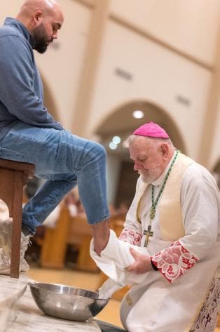 El arzobispo Thomas Wenski secó los pies del catecúmeno Lenier González después de lavárselos en la Catedral de Saint Mary.