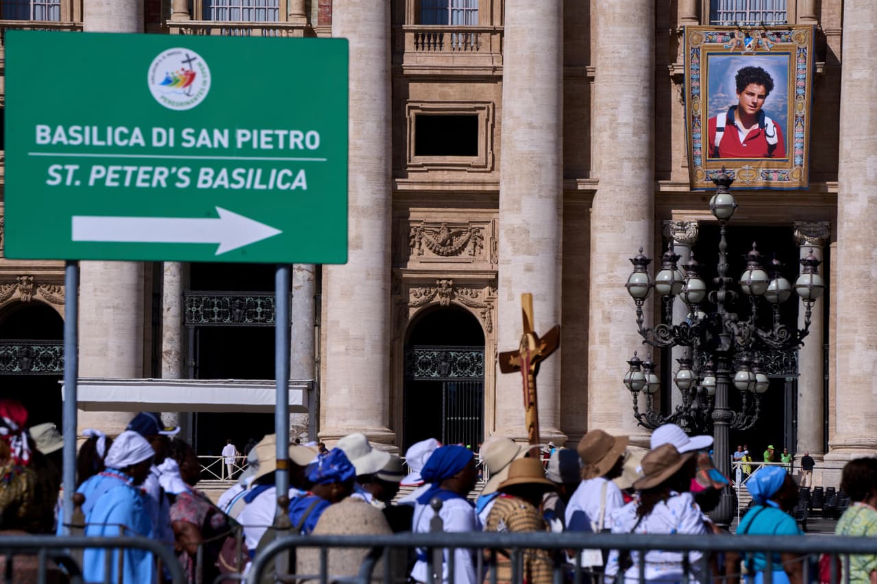 Un tapiz con el retrato del beato Carlo Acutis, quien será canonizado el domingo, cuelga en la fachada de la Basílica de San Pedro en el Vaticano, el jueves 4 de septiembre de 2025, mientras los peregrinos del Jubileo llegan para cruzar la Puerta Santa.