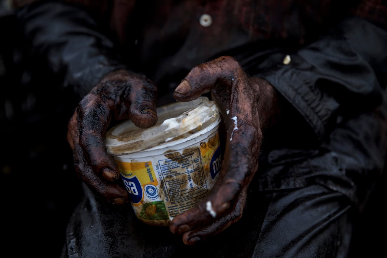 El pescador José Miguel Pérez, empapado en petróleo, sostiene un recipiente con sl almuerzo durante un descanso de la pesca de cangrejos en el lago de Maracaibo. “Esos pescadores venezolanos tienen una existencia infernal”, declaró Elferink. "Están en el epicentro de todo". El agua oleaginosa, los vapores tóxicos y la ingestión diaria de los productos contaminados pueden causar una gran variedad de enfermedades como dificultades respiratorias, lesiones dérmicas e incluso cáncer, estimó.