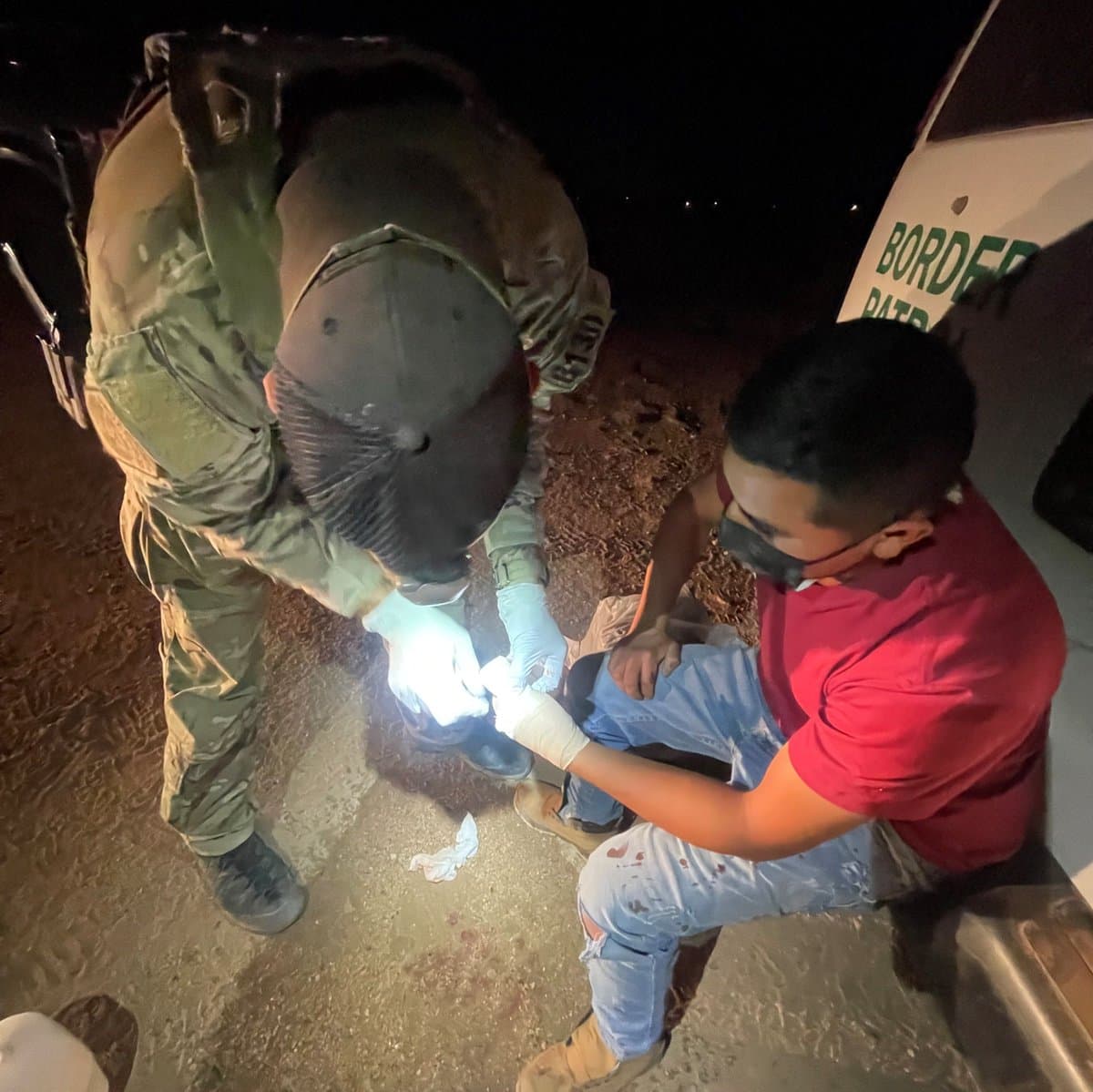 Un agente técnico de emergencias atiende a un inmigrante lastimado en la frontera.