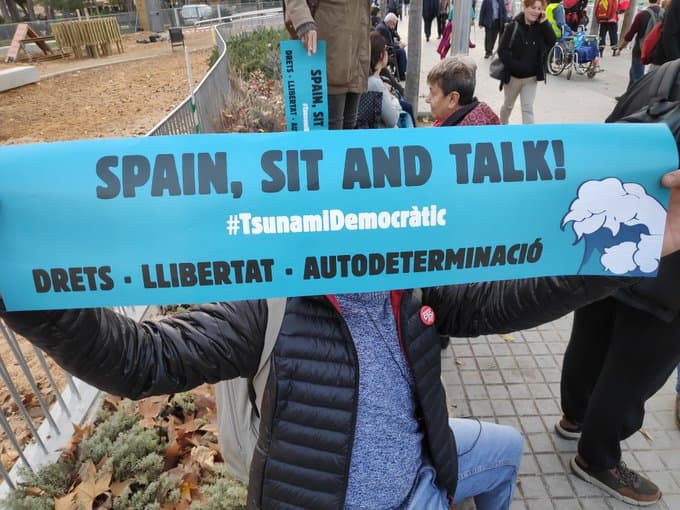 Los grupos de Tsunami Democàtic ya se reunen para protestar camino al Camp Nou. El movimiento independentista cuenta con 100 mil cartulinas con el lema 'Spain, sit and talk', mismas que reparten a la gente para ser mostradas después del himno del Barça.