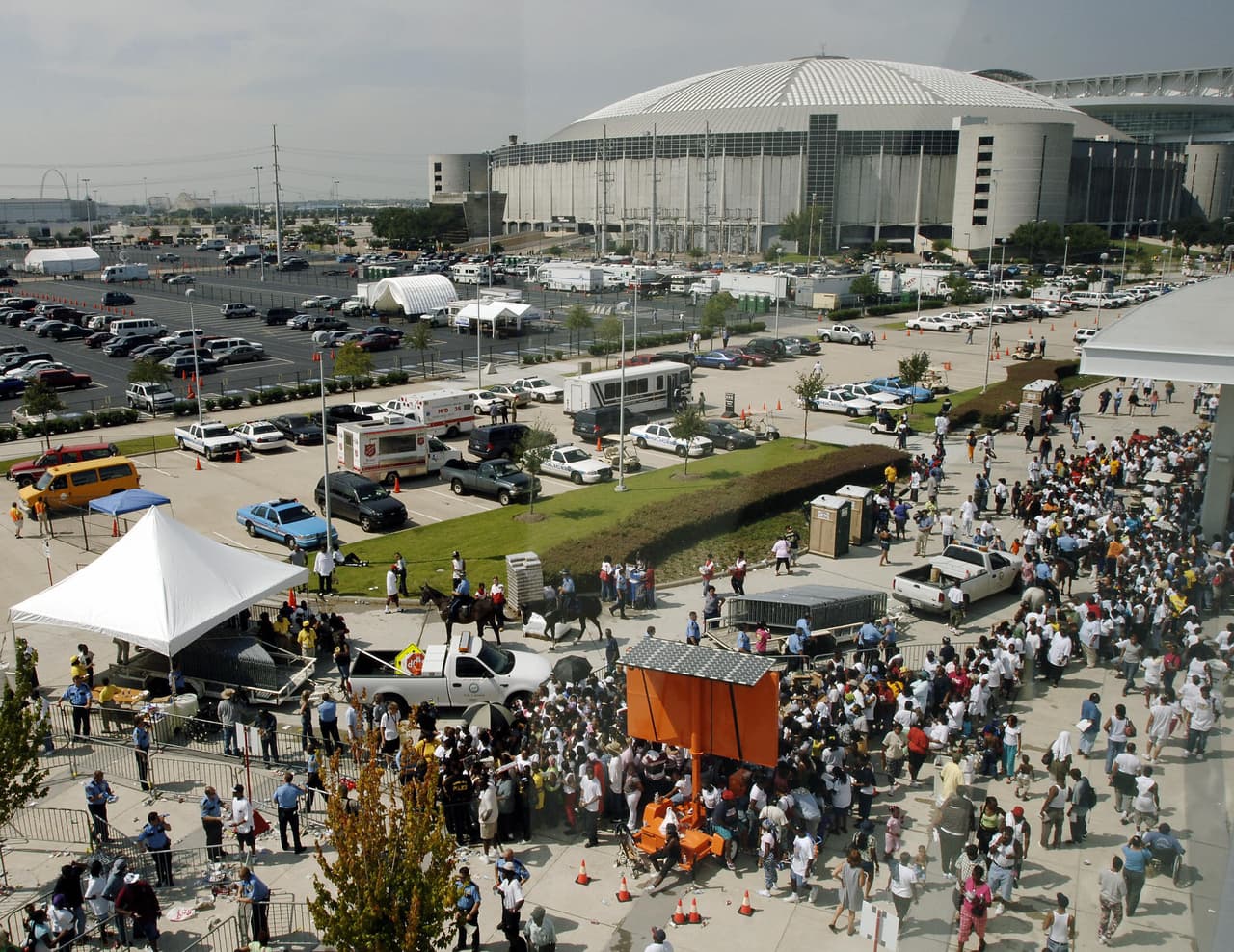 Houston, UNITED STATES: A crowd of Hurricane Katrina evacuees line up to receive a debit card from the Red Cross, 08 September, 2005, outside the Reliant Center in Houston, Texas with the Astrodome in the background. Evacuees were given the card with approximately $1,500 USD. AFP PHOTO/Stan HONDA (Photo credit should read STAN HONDA/AFP/Getty Images)