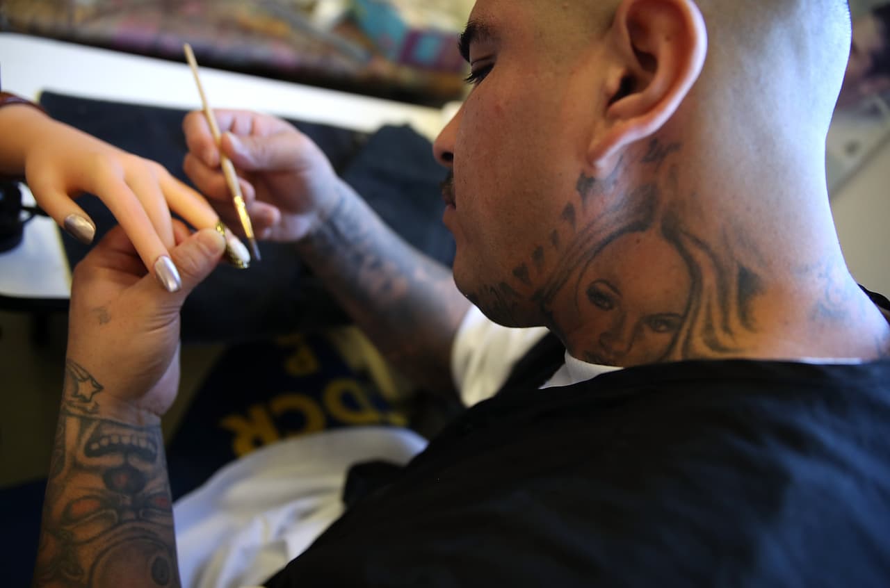Michael Espinosa, reo de la Prisión de Valley State, practica cómo pegar una uña artificial a una mano de maniquí durante su clase de cosmetología en la Prisión de Valley State, en marzo de 2017, en Chowchilla, California.