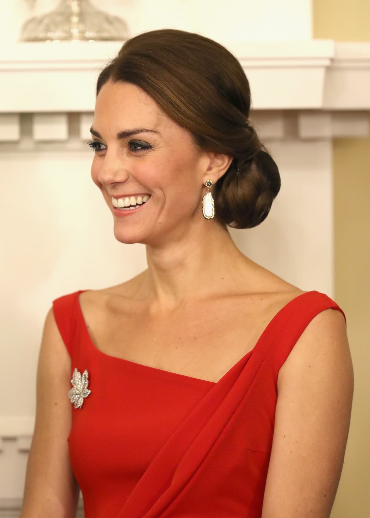 En un vestido rojo, de escote asimétrico de la casa Thornton Bregazzi hizo su aparición Kate Middleton en la primera ceremonia después de su llegada a Canadá. Usó de nuevo un broche de hoja de maple heredado de la reina madre, quien a su vez lo recibió de su marido en 1939 para celebrar su visita a esta nación.