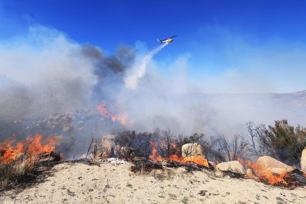 Cientos de bomberos se mantienen en la zona, donde hasta las rocas parecen encendidas.