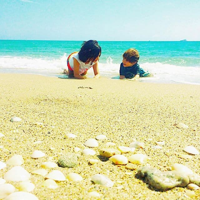 Ella y sus pequeños hijos están tomando unos días de vacaciones en la playa.