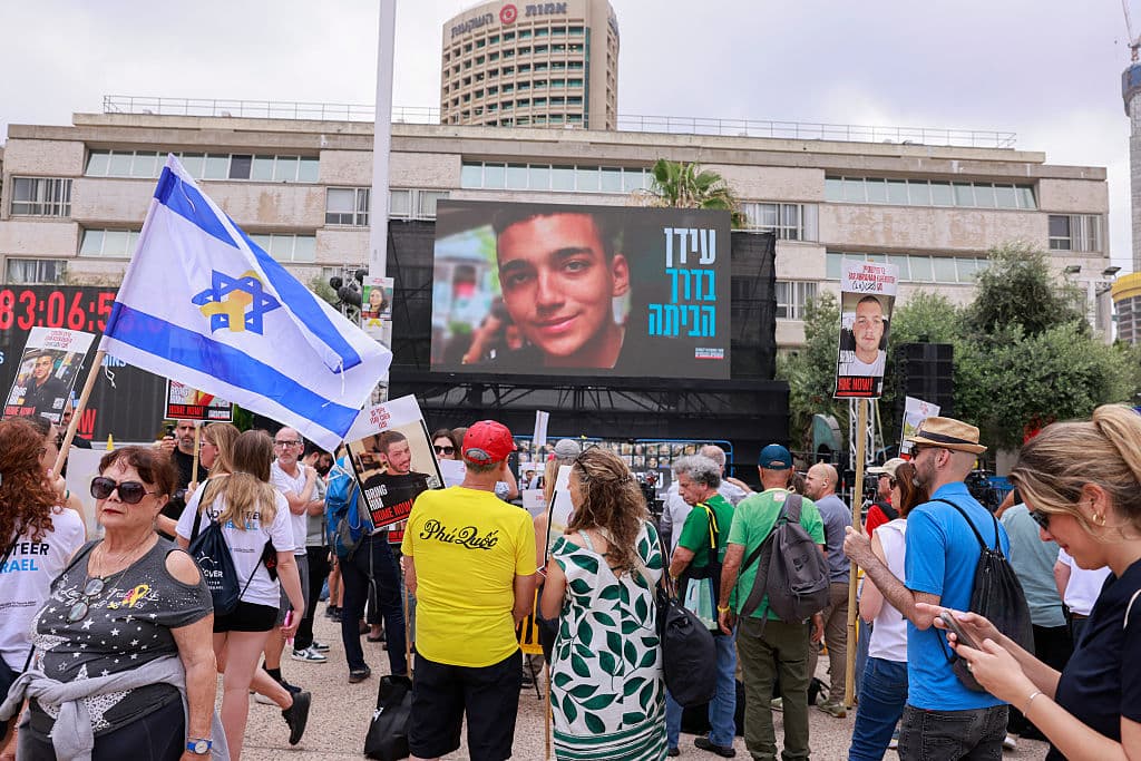 Personas pidiendo por la liberación de los rehenes que quedan en Gaza en Tel Aviv. En la foto principal, Edan Alexander, el rehén israelí estadounidense que será liberado hoy, según Hamas.