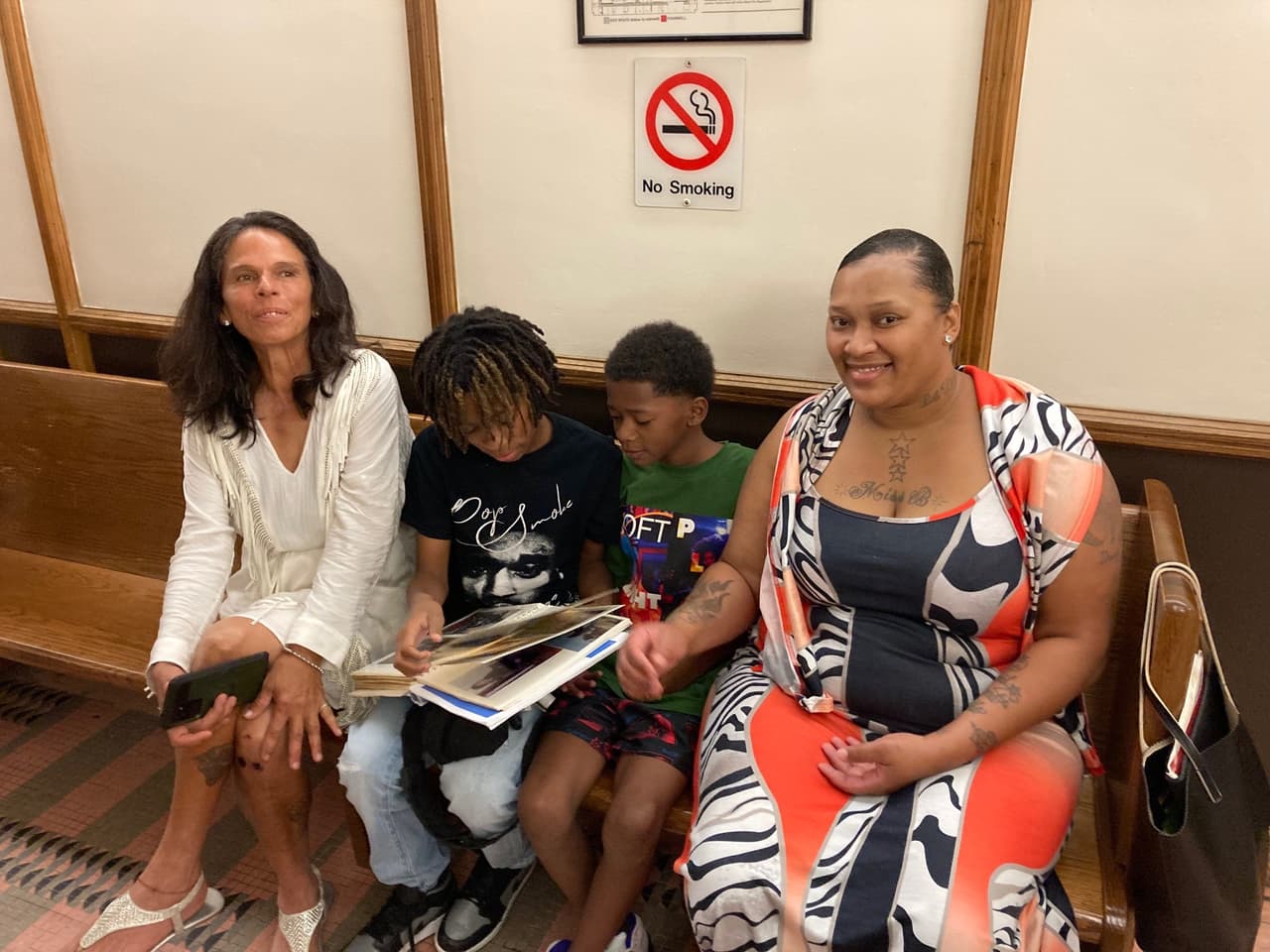 La familia de Ángel Sánchez revisa su libro de fotos y recortes en el juzgado de Miami. De izquierda a derecha su madre, Dexis Montiel, sus sobrinos Raynard y Raynaldo McNealy, y su hermana, Betsy Montiel. 16 de septiembre, 2022.