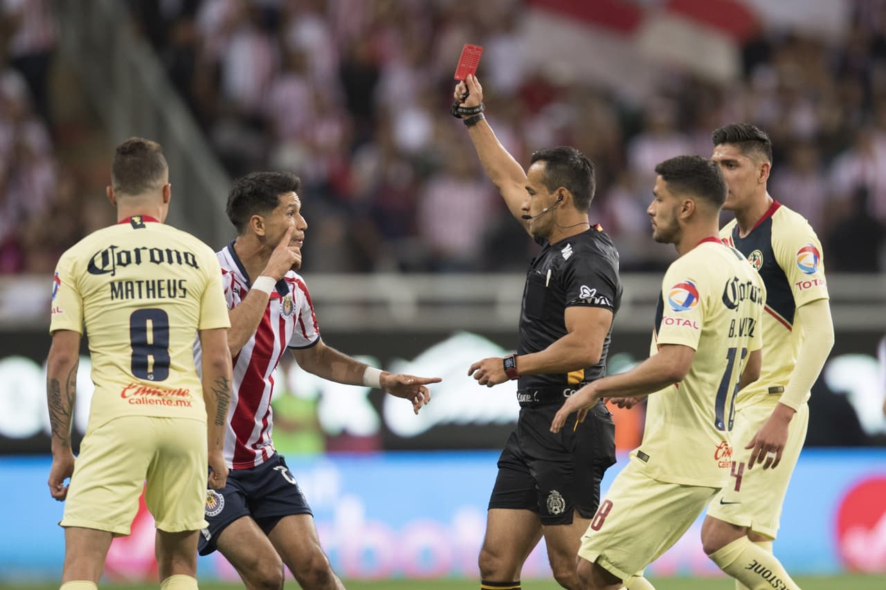 Sin embargo, al minuto 37 el árbitro Jorge Isaac Rojas (centro) expulsó con roja directa a Jesús Molina de Chivas.