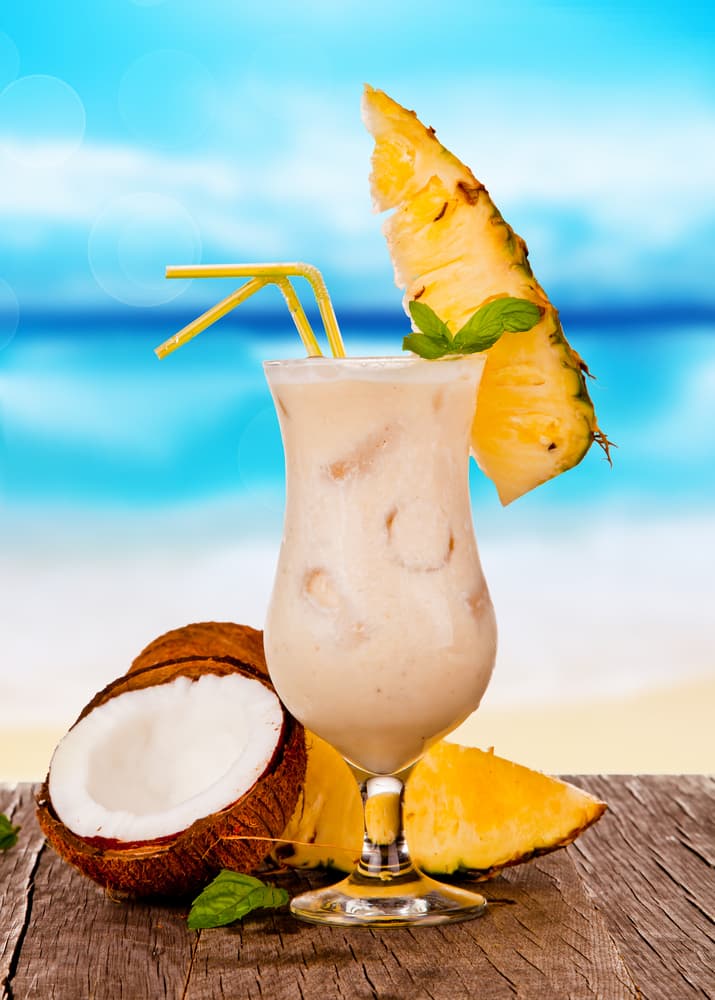Piña colada. Prepara en casa las mejores piñas coladas y disfruta del verano al cien por ciento. Dale un giro a la bebida hazla en un suave mousse o un helado. Los ingredientes son: hielo, 1.5 oz de ron blanco, 1.2 oz de crema de coco, zumo o jugo de piña, rodaja de piña y guinda