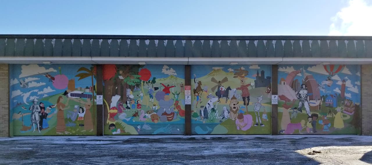 El mural "Arte de la historia" fue diseñado por Stuart Patterson, quien es director de la Shimer Great Books School en el North Central College. Él hizo gran parte del mural solo, pero voluntarios lo asistieron esporádicamente. En el mural encontrarás personajes y lugares literarios famosos, desde Harry Potter y el Dr. Seuss 'Lorax, hasta el Mago de Oz y el Jinete sin Cabeza de "The Legend of Sleepy Hollow". El mural está en la esquina sureste de Martin Luther King Jr. Avenue y Clayton Street.