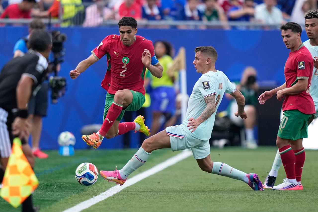 Lucas Digne tratándole de quitar el balón a Achraf Hakimi.