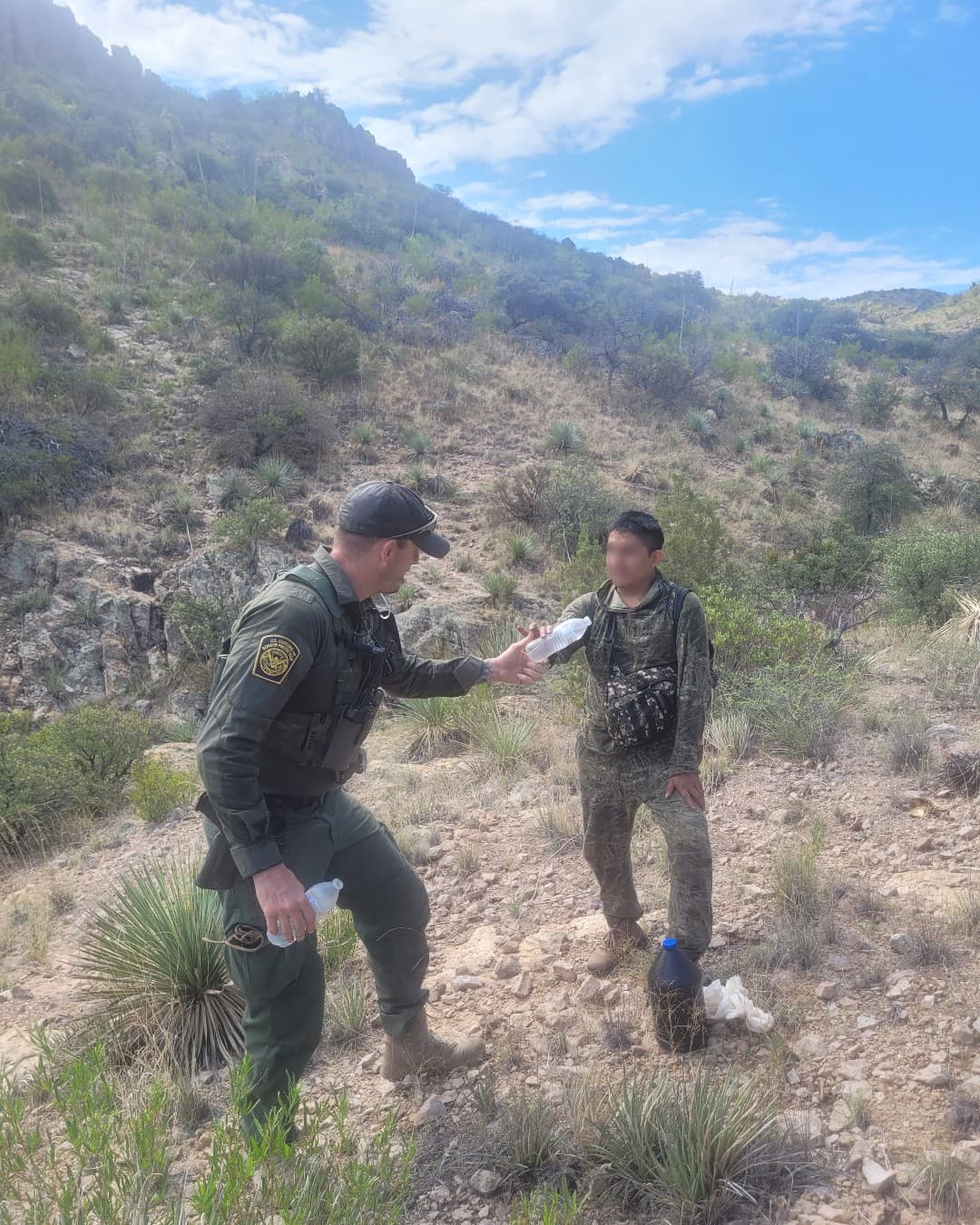 Según la Patrulla Fronteriza cada rescate es diferente. Algunos requieren atención médica avanzada, mientras que otros simplemente requieren líquidos para salvar vidas. Un agente de la estación de Tucson proporciona agua a un migrante deshidratado cerca de Arivaca, Arizona.