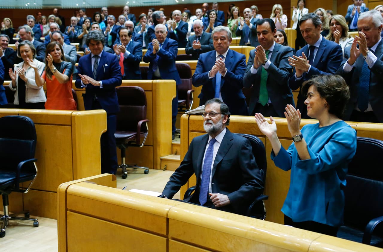 Minutos después de la declaración catalana de independencia (con 70 votos favorables de 135), el Senado español aprobó por mayoría absoluta la activación del artículo 155 de la Constitución, que permite al Gobierno central aplicar medidas de intervención en Cataluña. En la fotografía el presidente del gobierno, Mariano Rajoy, es aplaudido por sus colegas parlamentarios en Madrid, luego de la aprobación de las medidas para intervenir Cataluña.