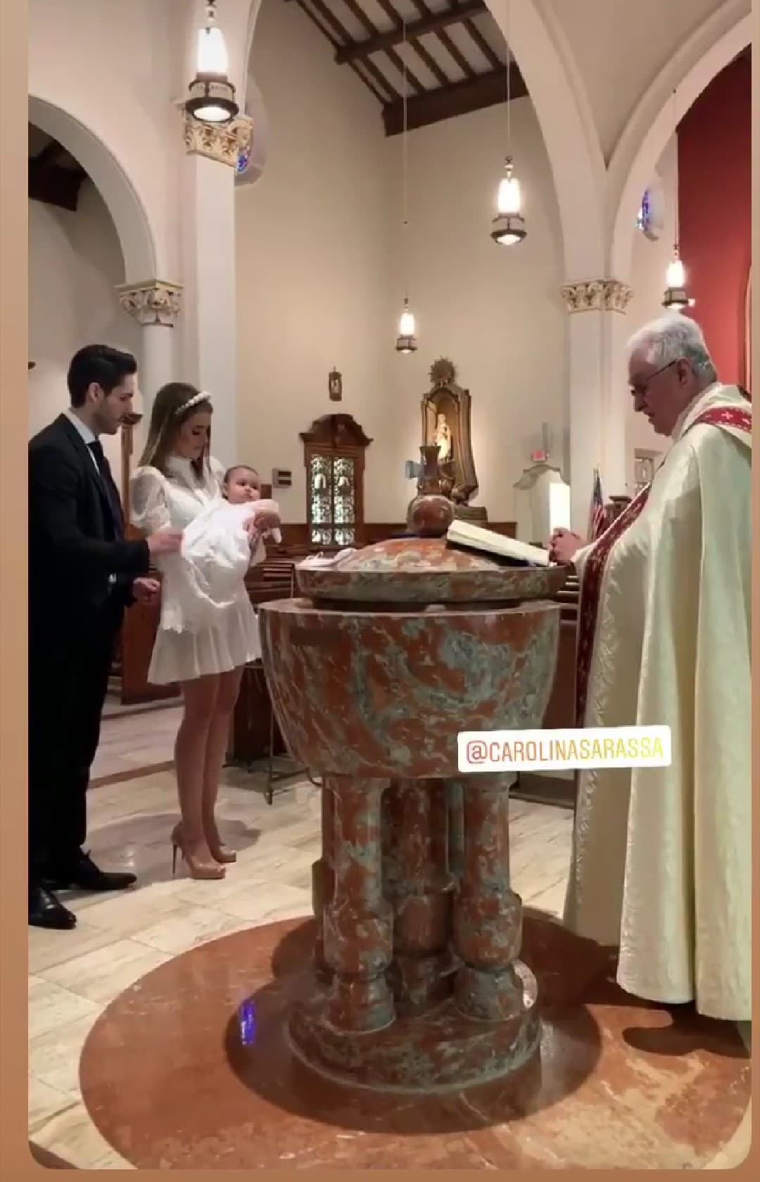 Los orgullosos padres estaban felices de presentar a su hija en la iglesia católica.