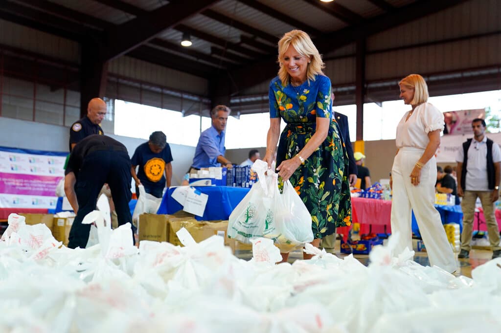 Caridad Pierluisi siguió revisando que todo marchara a la perfección, mientras que Jill Biden siguió llenando bolsas con alimentos.