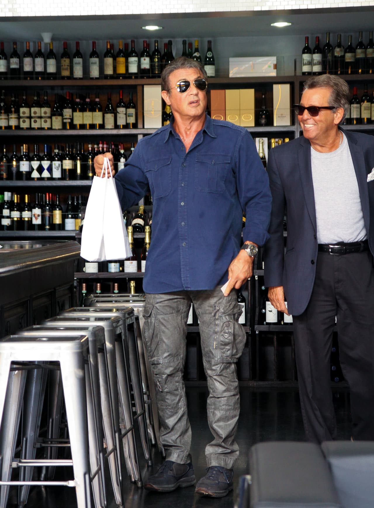 El actor, productor y guionista, Sylvester Stallone pasó un día muy entretenido en Beverlly Hills comprando sus vinos favoritos. El actor paso algunas horas escogiendo uno que se adecuara a sus gustos pidiendo las opiniones de los vendedores. Quizá Stallone tenía una cena en casa y necesitaba un vino especial. Al salir del lugar sonrío a las cámaras y se mostró muy relajado en su día de compras.
