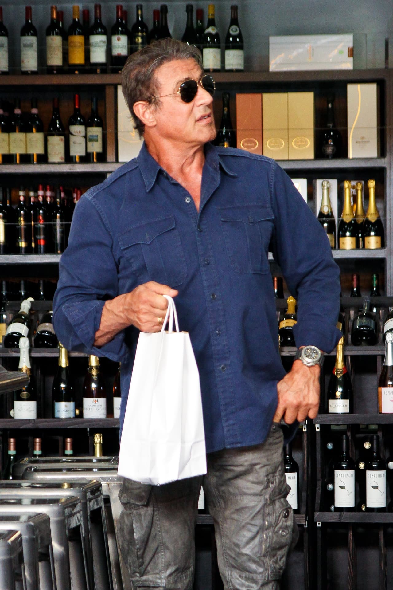 El actor, productor y guionista, Sylvester Stallone pasó un día muy entretenido en Beverlly Hills comprando sus vinos favoritos. El actor paso algunas horas escogiendo uno que se adecuara a sus gustos pidiendo las opiniones de los vendedores. Quizá Stallone tenía una cena en casa y necesitaba un vino especial. Al salir del lugar sonrío a las cámaras y se mostró muy relajado en su día de compras.