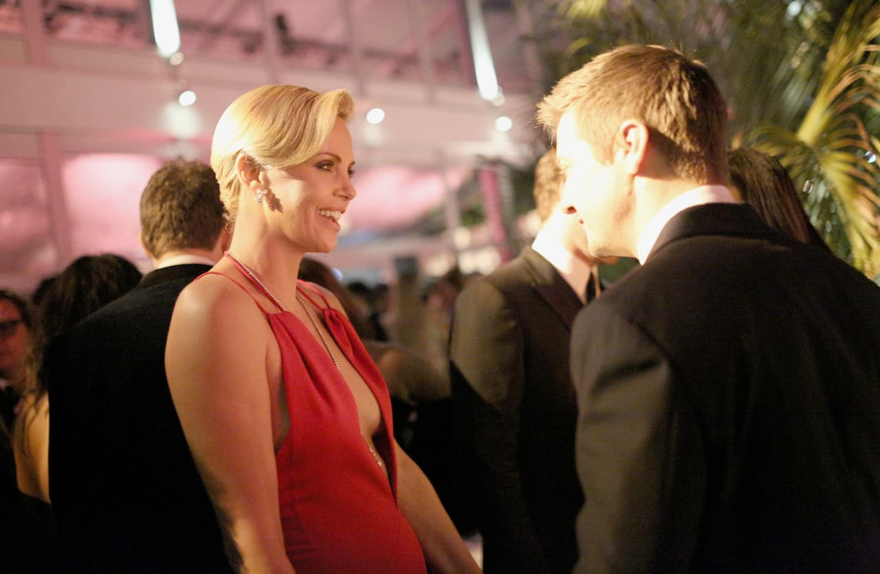 Charlize plática y plática con Jeremy Renner.