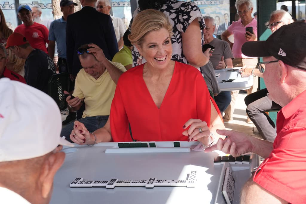 La reina Máxima conversa mientras juega dominó.