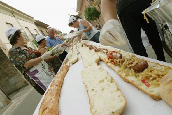 Los pobladores hacen los preparativos para un sándwich de un kilometro en su intento de establecer un nuevo libro Guinness récord mundial el 1 de junio de 2003, en Pastoano, Italia.