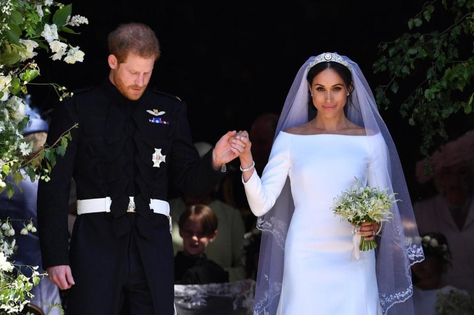 Meghan nos sorprendió con una prenda nupcial lisa ajustada al cuerpo de triple organza de seda.