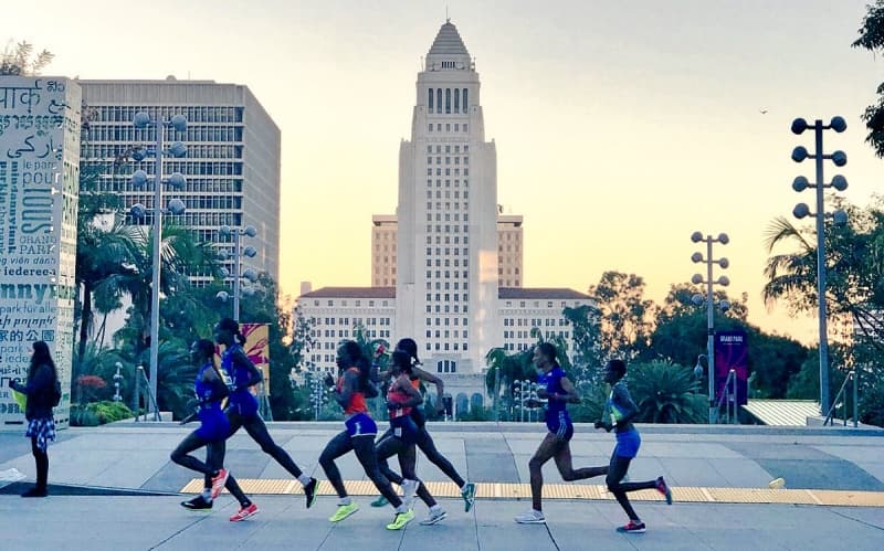 Corredoras frente al edificio histórico del City Hall de Los Ángeles durante la ruta del maratón.
