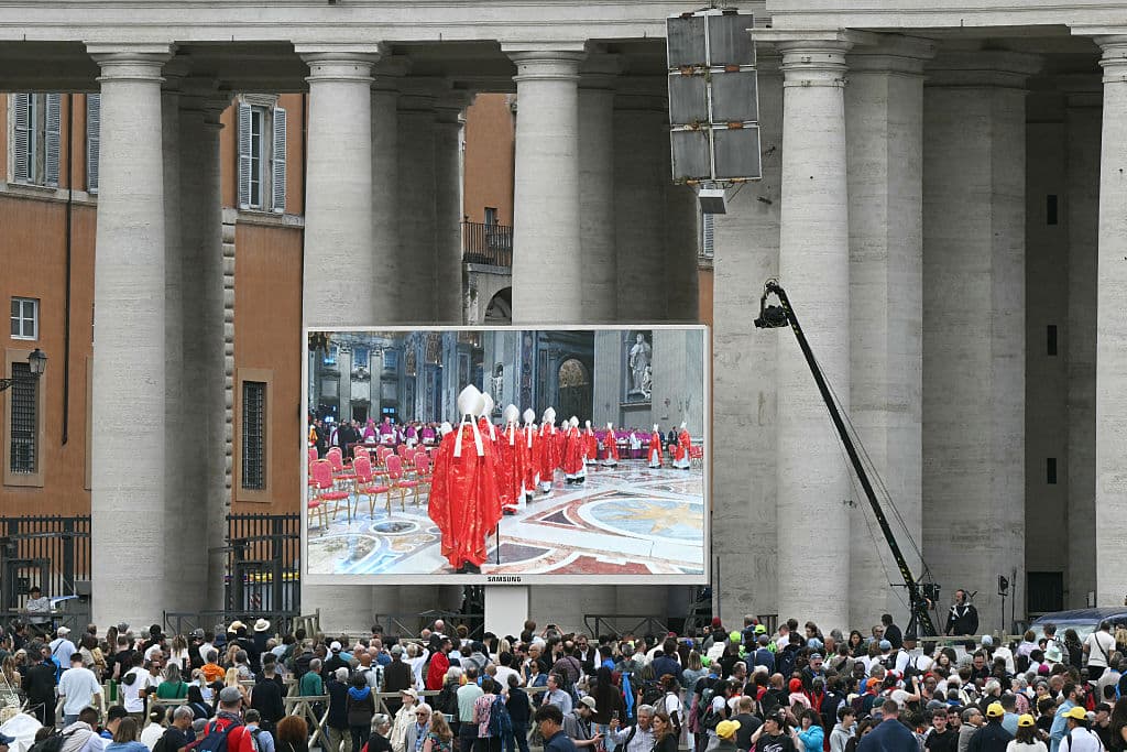 Fieles viendo la misa previa al cónclave este miércoles en una pantalla en la Plaza de San Pedro en el Vaticano.