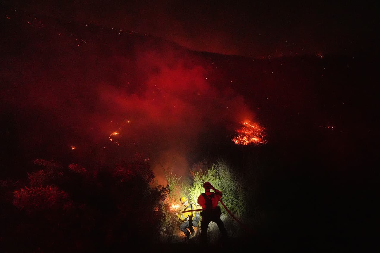 Los equipos de bomberos se mantienen firmes frente al incendio la noche del jueves.