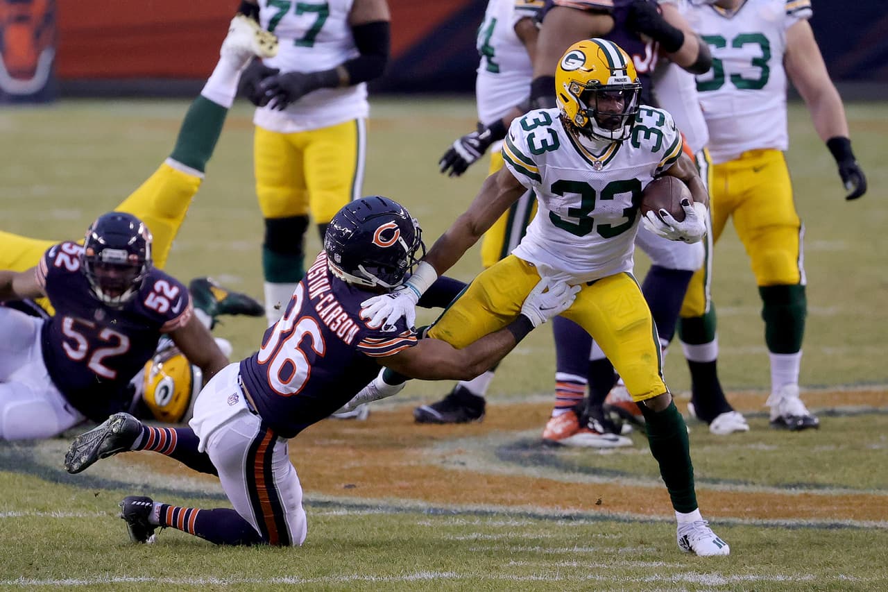 CHICAGO, ILLINOIS - JANUARY 03: Aaron Jones #33 of the Green Bay Packers runs with the ball against DeAndre Houston-Carson #36 of the Chicago Bears during the first quarter in the game at Soldier Field on January 03, 2021 in Chicago, Illinois. (Photo by Jonathan Daniel/Getty Images)