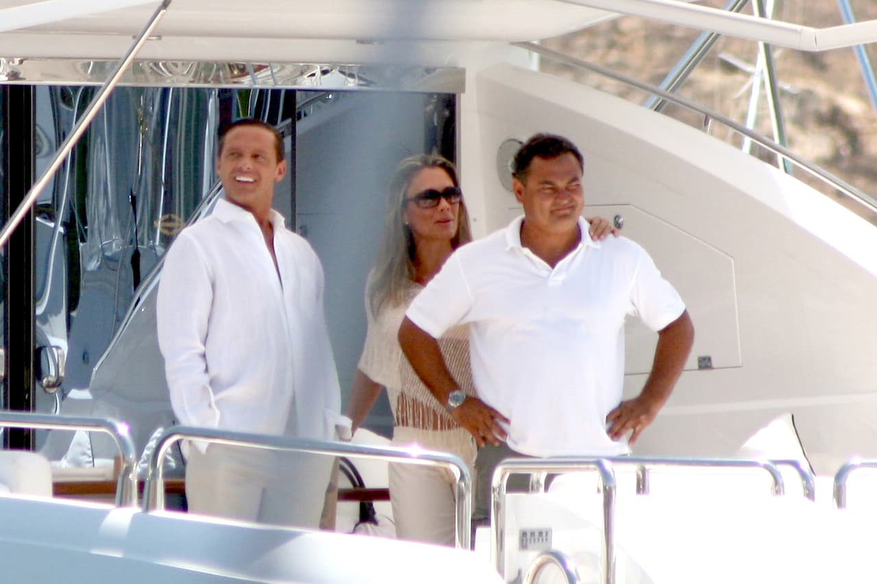 Luis Miguel en la cubierta de su yate en Los Cabos, Baja California, junto con una amiga y el capitán del navío, unos días después del bautizo de su hijo Miguel, en el puerto mexicano. México, 7 julio 2007.