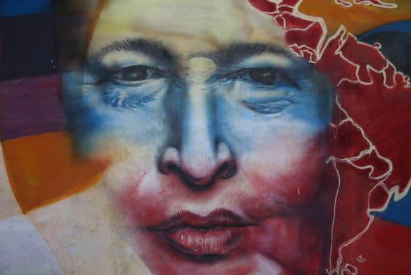 A un año de su muerte , la imagen de Chávez sigue apareciendo en los edificios y rincones del país .