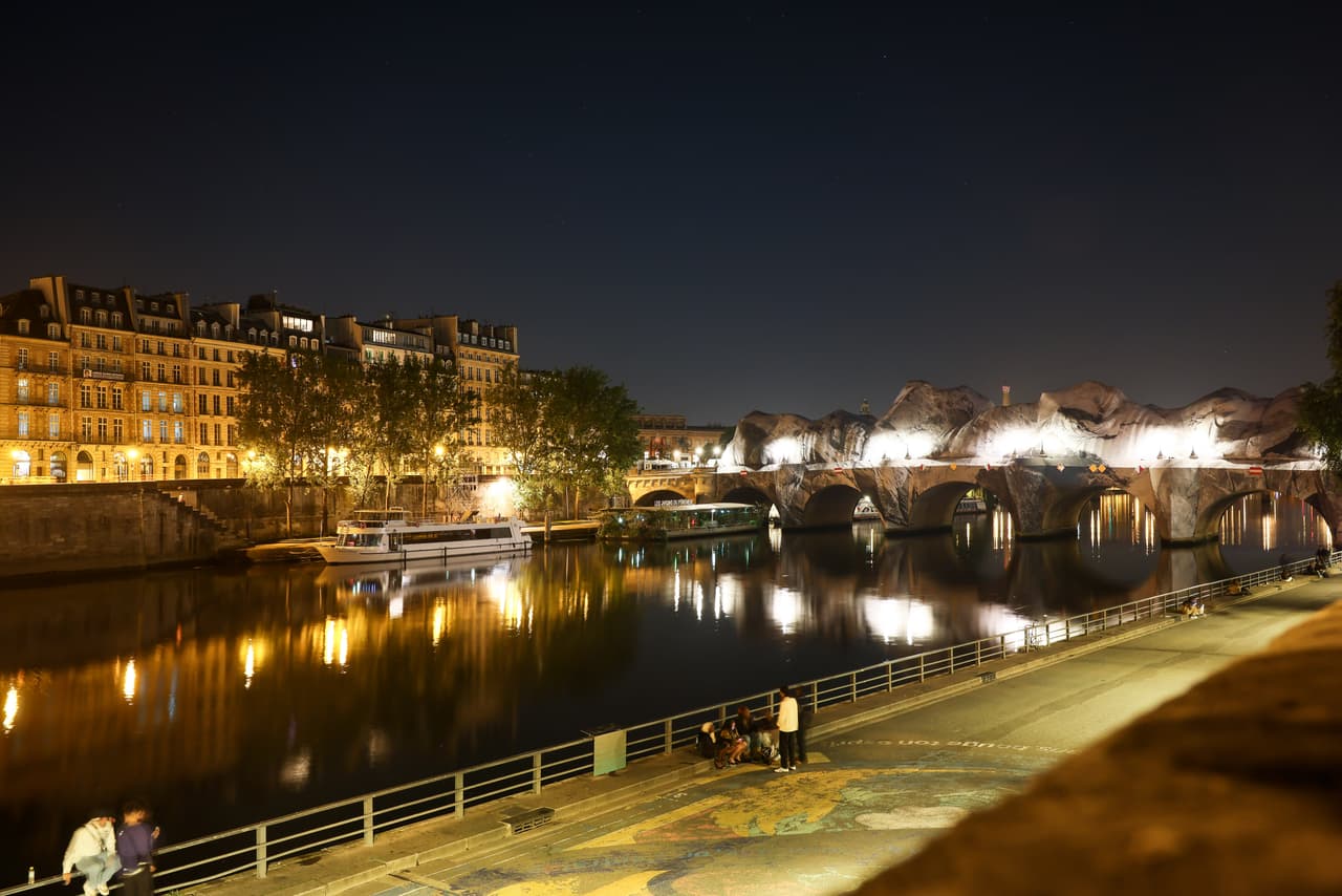 Inflado de la obra de arte "La cueva del Pont Neuf" del artista callejero francés JR en el puente Pont Neuf, con la Torre Eiffel de fondo, el miércoles 20 de mayo de 2026, en París, antes de su inauguración gratuita al público del 6 al 28 de junio. (Foto AP/Thomas Padilla)
