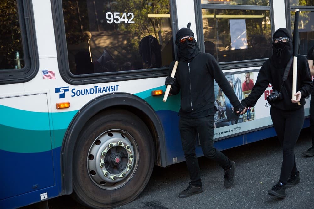 Dos manifestantes anticapitalistas vestidos de negro y con la cara cubierta. Según la policía, se arrojaron piedras, ladrillos y cócteles molotov durante el recorrido por Seattle.